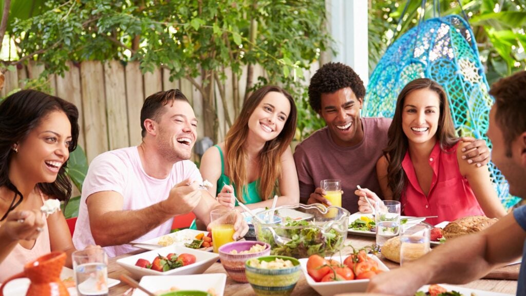 A group of friends enjoying authentic connection and laughter outdoors, symbolizing the power of genuine relationships.
